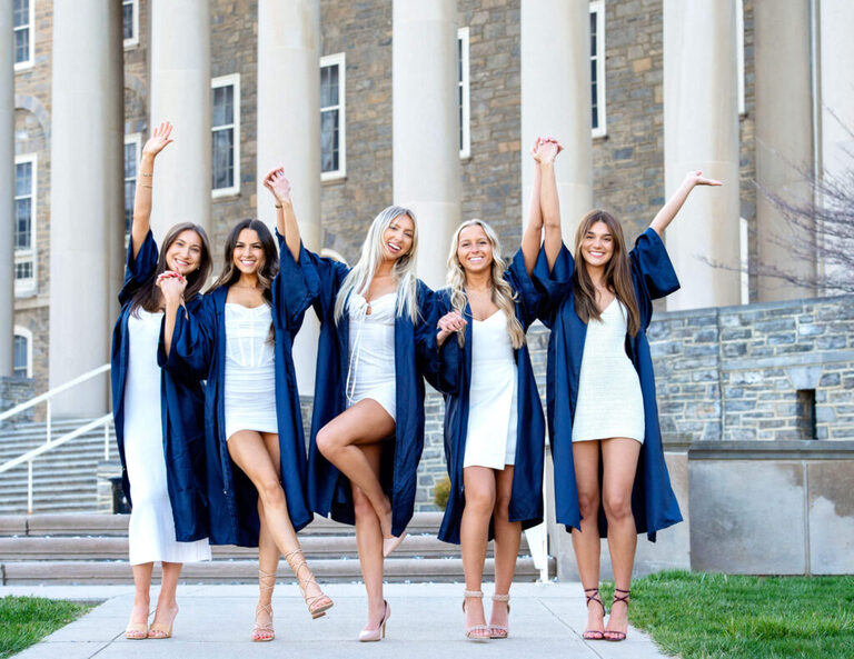 PSU Grads holding hands up in the air together in front of Old Main 